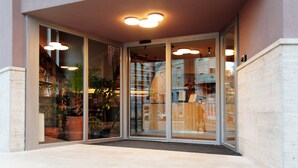 A hotel entrance with glass doors, a tiled entrance area, and a reflection of the interior. - Maverick Central Market (Budapest)