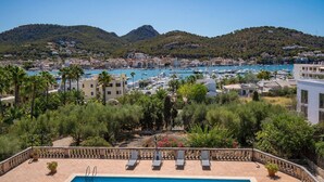 A coastal resort with a pool, lounge chairs, and a marina with boats. - Villa overlooking the Port of Andratx with private pool (Port D'Andratx)