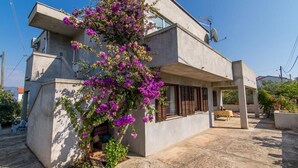 A two-story concrete house with a balcony, a satellite dish, and a flowering plant. - Apartment in Slatine with Terrace, Air condition, WIFI (4789-2) (Slatine)