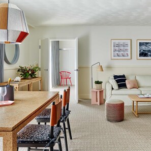 Een moderne woonkamer met een bank, een salontafel en een eethoek met een tafel en stoelen.