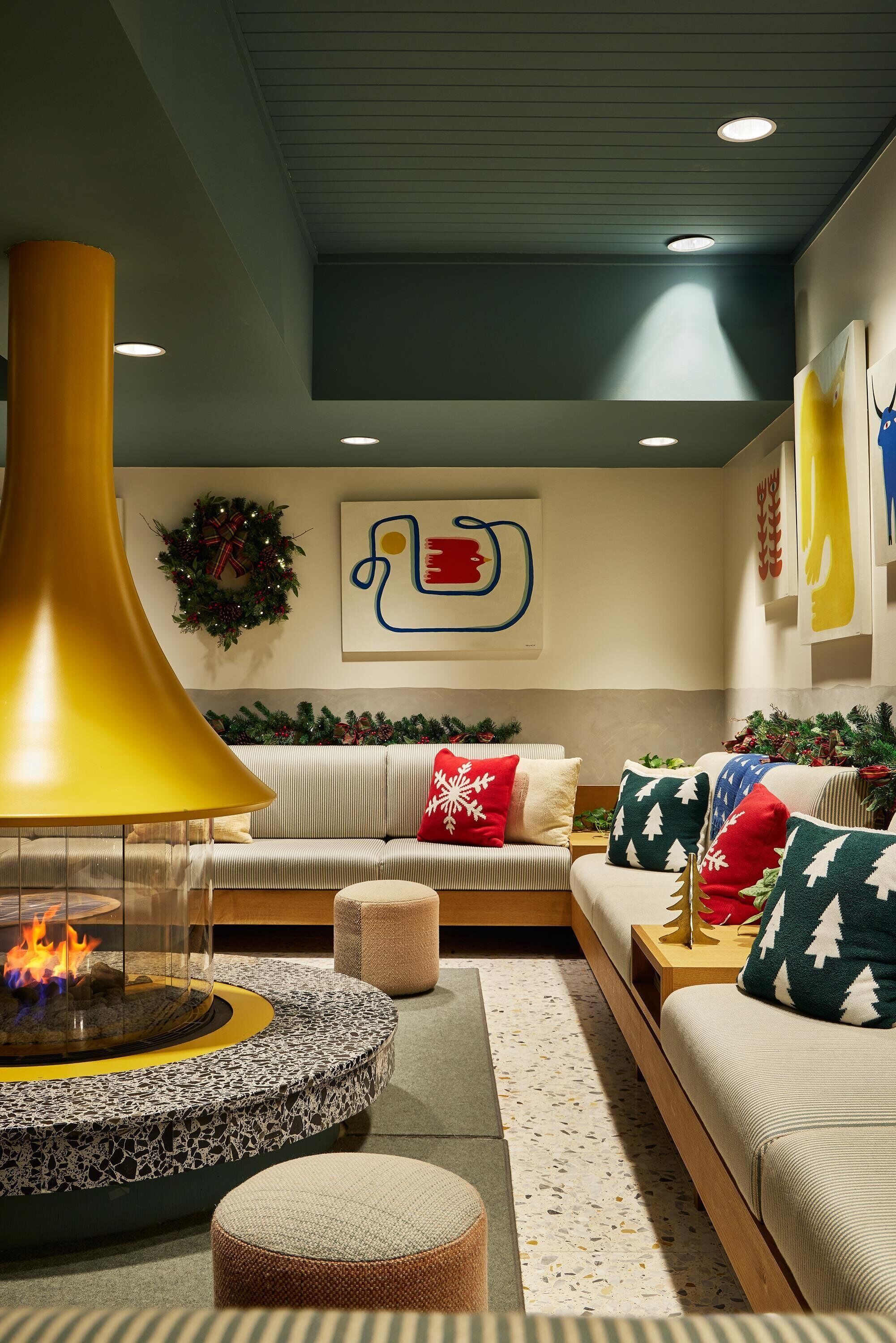 A modern living room with a fireplace, a sofa set, and holiday decorations.