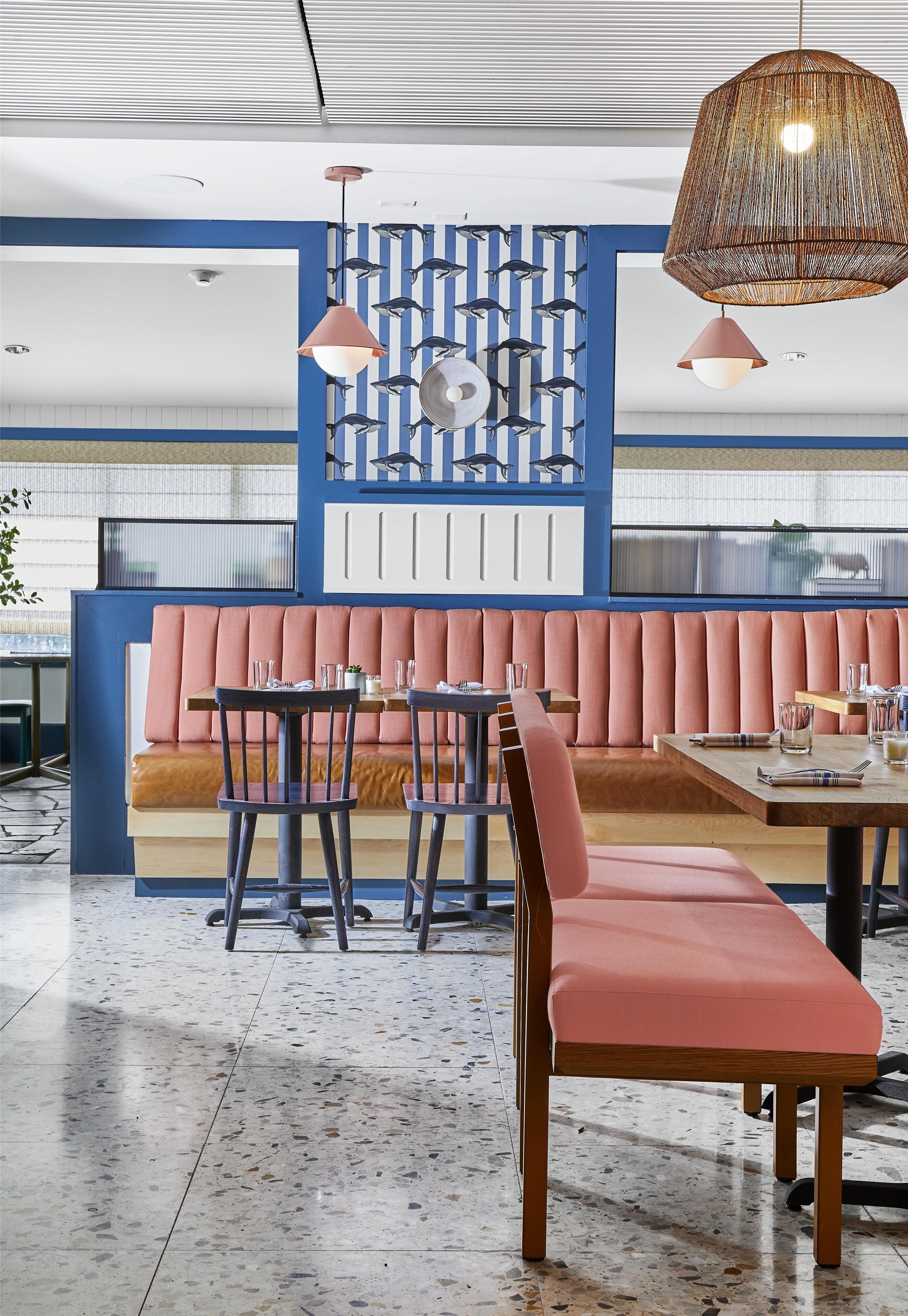 A modern interior with a seating area, tables, and pendant lighting.