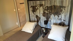 A room with two beds, each with a pillow and a small bedside table with a candle. - Gite de Gazelle Chambres d'Hote (La Vacquerie-et-Saint-Martin-de-Castries)