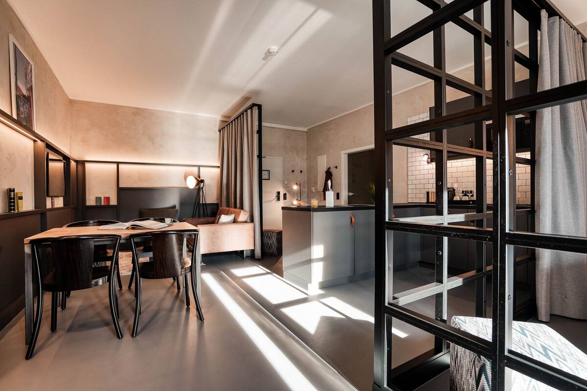 Et moderne interiør med spiseplads, sofa og køkken.