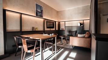 Een moderne woonkamer met een houten eettafel, twee stoelen, een bank en een open haard.