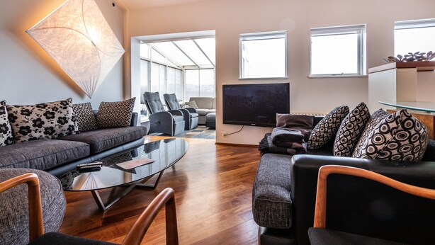 Un salon moderne avec un canapé, une table basse et un téléviseur.