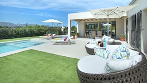 A modern outdoor patio with a pool, wicker furniture, and umbrellas. - VILLA MIR - LUXURY RETREAT (Pollensa)