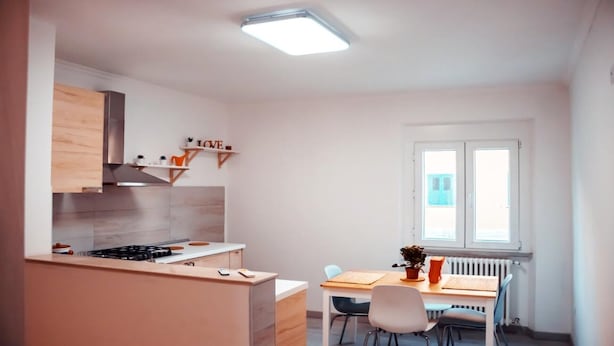 A modern kitchen with a gas stove, wooden cabinets, and a window with blinds. - Apartment two bedrooms two bathrooms (Ancona)