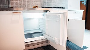 Una cocina moderna con refrigerador empotrado, estufa a gas y una encimera.