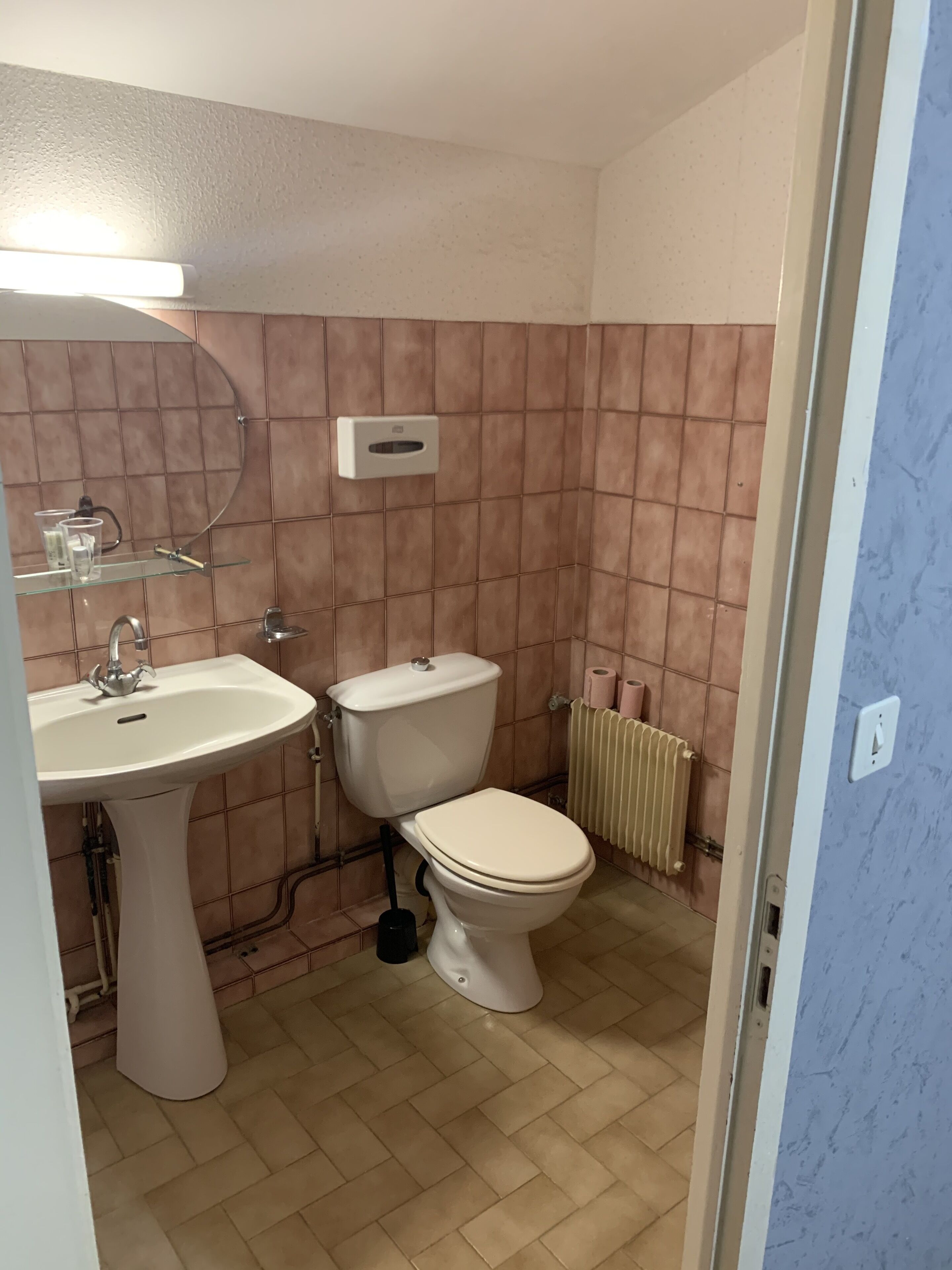 Ein Badezimmer mit Waschbecken, Toilette und Wandtrockner.