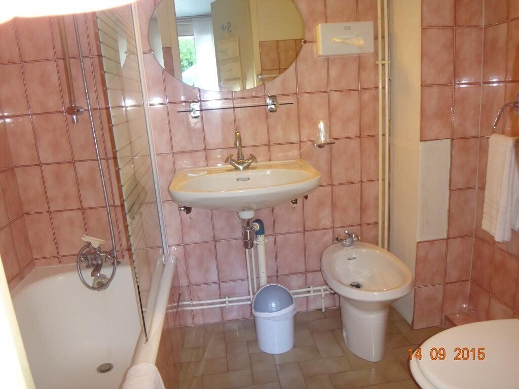 A bathroom with a bathtub, a sink, and a bidet.