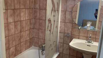 Un baño con bañera, lavabo y espejo.