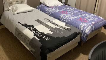A double bed with a Times Square-themed bedspread and a Central Park-themed headboard.