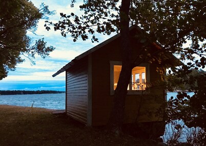 Cottage with sunny wooden deck by water