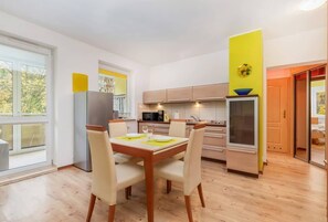 Una cocina moderna con una mesa de comedor, sillas y un refrigerador.