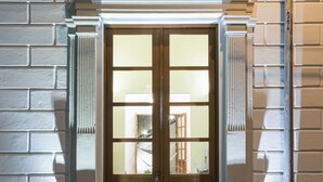 A double door with a classical architectural design, flanked by columns, and a decorative arch above. - Villa Orquidea Boutique Hotel (Mérida)