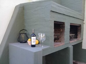 A bottle of wine, two glasses, and a lantern on a ledge.