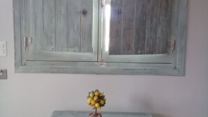 Ein Zimmer mit einer rustikalen Holztür, einem kleinen Tisch mit einem Topfpflanzen und einem hellen Boden.
