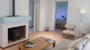 Ein Wohnzimmer mit Kamin, einer Couch, einem Couchtisch und einer Lampe.