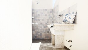 A modern bathroom with a shower, a sink, and a tiled wall. - I tre Golfi Azzurra (San Vito Lo Capo)