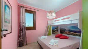 Un dormitorio con una cama litera, una ventana con vistas, una cortina y un cuadro en la pared.