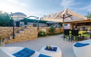 An outdoor patio area with stone steps, outdoor seating, and a covered dining area. - Villa Mirela (Cibaca)