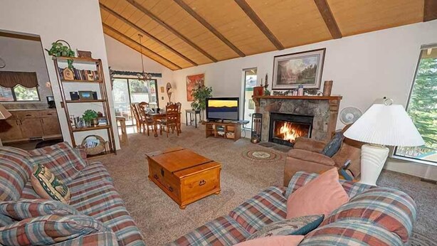 A cozy living room with a fireplace, a television, and a bookshelf.
