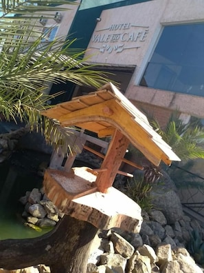 A wooden structure with a roof, possibly a decorative feature or part of a garden.