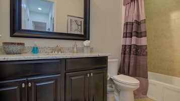 Bathtub, hair dryer, towels, shampoo