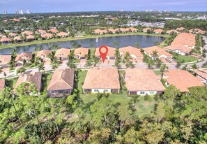 A residential area with houses, a lake, and a red location marker.