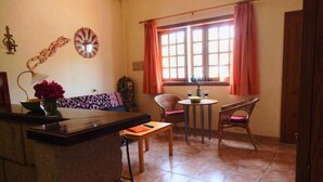 Una sala de estar acogedora con un sofá, una mesita y una ventana con cortinas.