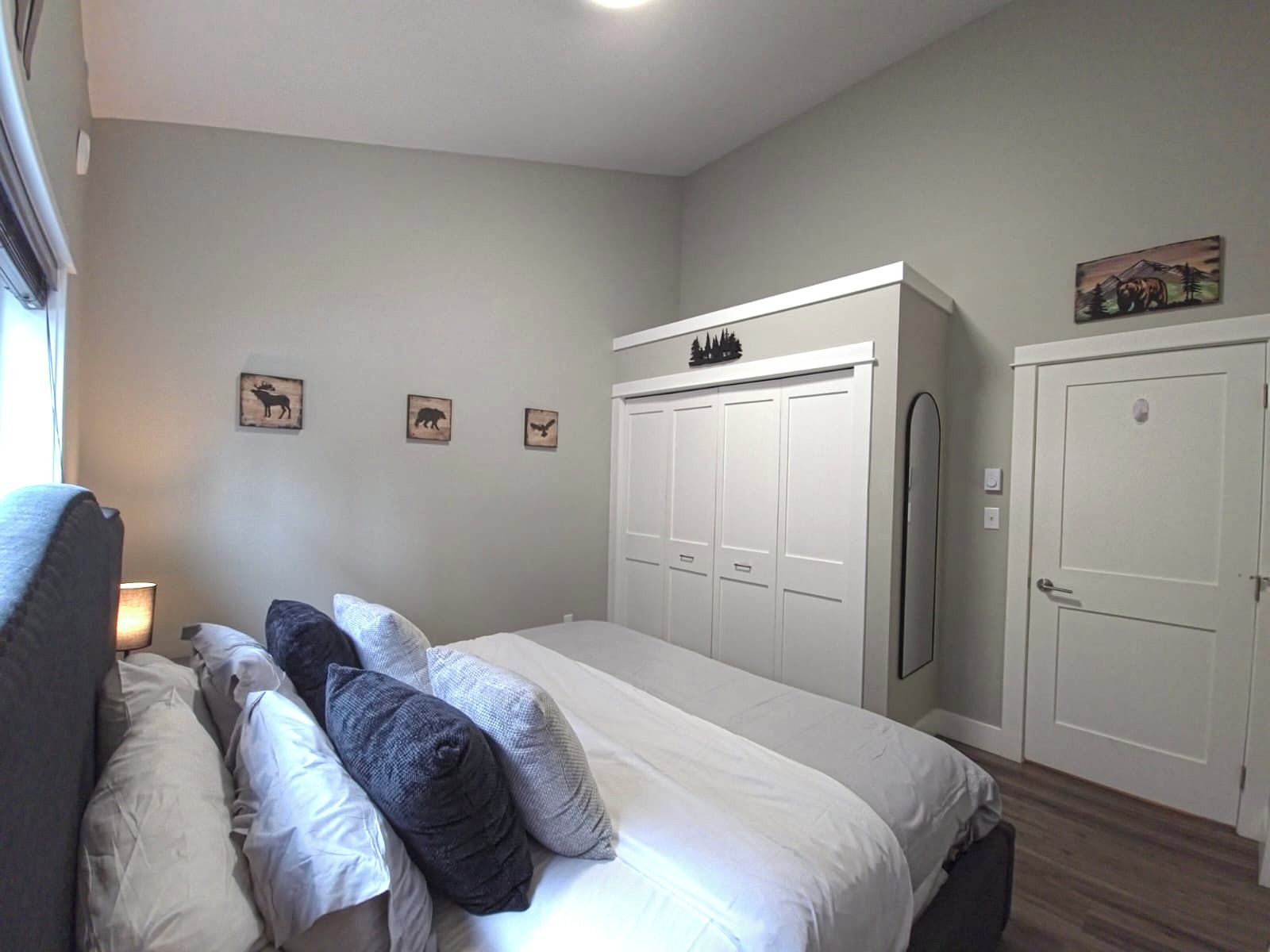 Un dormitorio con cama, armario y puerta.
