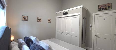 Un dormitorio con cama, armario y puerta.