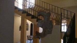 A staircase with ornate metal railings and a decorative stone sculpture. - Mayan Hotel Boutique (Mérida)