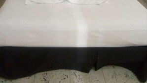 A neatly made bed with a heart-shaped towel arrangement in the center. - Mayan Hotel Boutique (Mérida)