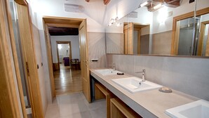 Ein modernes Badezimmer mit einem langen Waschtisch, zwei Waschbecken und einem großen Spiegel.