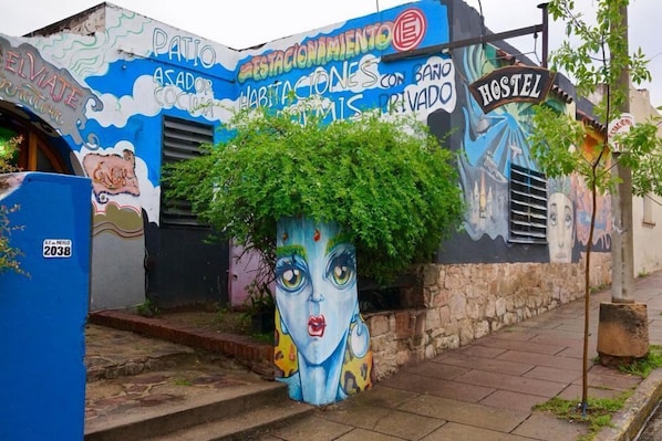 Un hostal con murales coloridos y un letrero que indica que es un hostal privado.