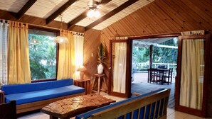 Una cabaña de madera con un sofá azul, una mesa de madera y una planta en maceta.