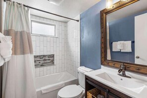 Une salle de bain avec une baignoire, des toilettes et un lavabo.