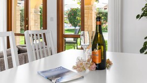 A table with a bottle of Maschio Prosecco, a glass, and a magazine.