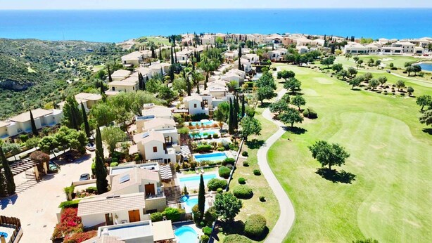 A coastal resort with villas, a golf course, and a swimming pool area.