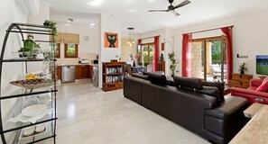 Una sala moderna con un sofá, un sillón rojo y un televisor.