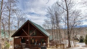 A cabin with a porch, a small deck, and a covered outdoor area. - Located 1.5 mi. from the Parkway in Pigeon Forge. (Pigeon Forge)