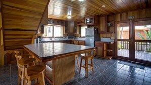 Una cocina amplia con una isla grande, taburetes de madera y un ventilador de techo.