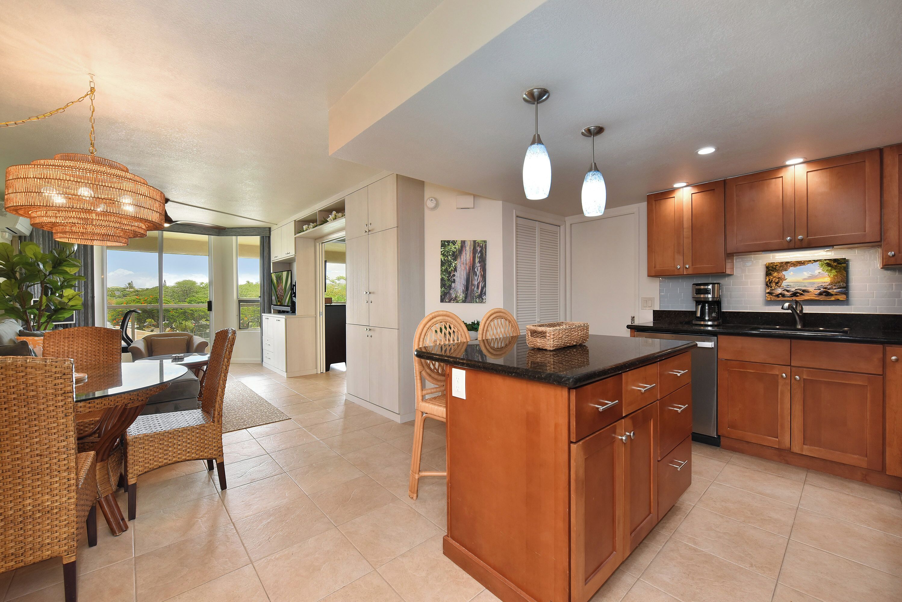 A modern kitchen with wooden cabinets, a central island, and pendant lighting.