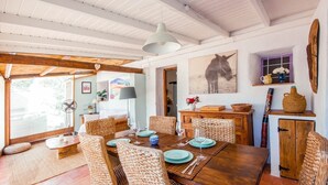 A dining area with a wooden table set for four, surrounded by wicker chairs. - The Casita Spain Huércal-Overa by Ruralidays (Almería)