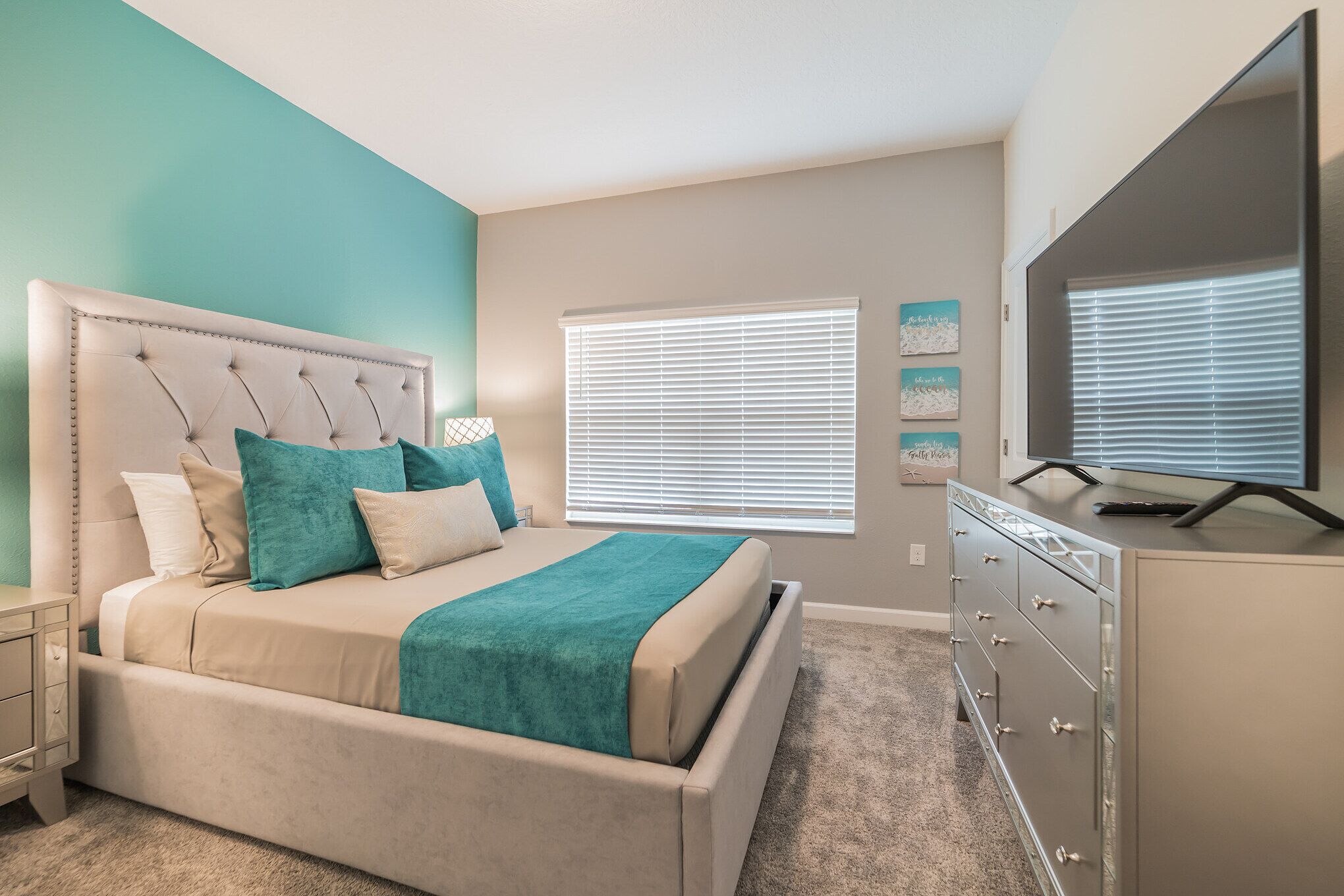 Une chambre à coucher avec un lit, une commode et un téléviseur.