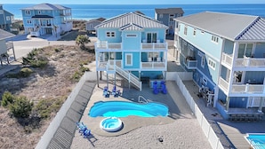 A beachfront property with a swimming pool, multiple balconies, and a view of the ocean. - Luna's: Amazing Ocean View House with Pool, Spa, Elevator and Electric Car Charg (Oak Island)