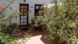A white building with a tiled roof, a door labeled "CALMA", and a window with a white blind. - Calma, quiet studio with sea view terrace overlooking the pool (Las Zocas)