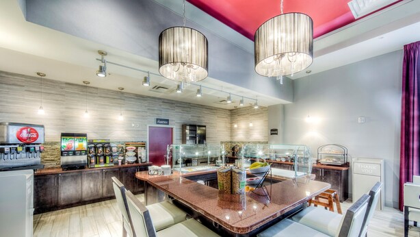 Una cocina moderna con una isla central, un refrigerador Coca-Cola y varios dispensadores de comida.